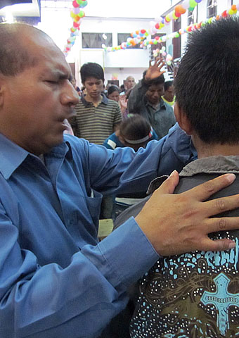 A pastor prays for a man during a service held in Chiapas, Mexico where Christians often are persecuted for not practicing folk Catholicism.