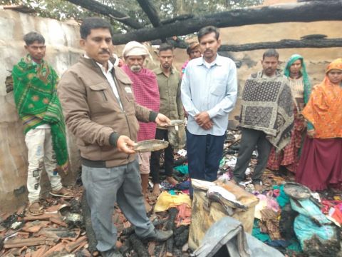 Members of a Christian family examine the remains of their home, burned down by Hindu extremists.