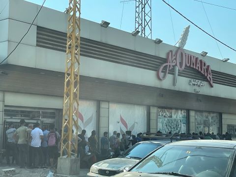 A long bread line at a bakery in a Middle Eastern country experiencing food shortages.