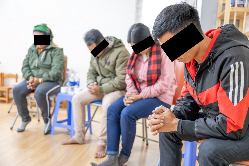 Hien (second from right) and Cai (far right) pray with other persecuted tribal Christians.