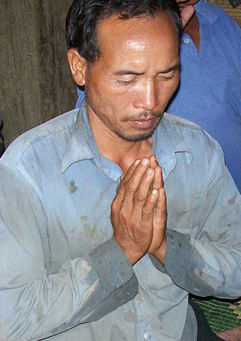 This man, from another area of Laos where Christians face persecution, prays during a church service