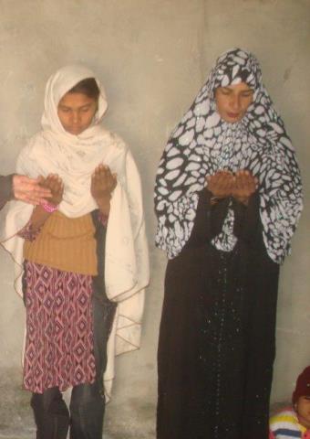 Two girls from a Christian and Muslim background pray together